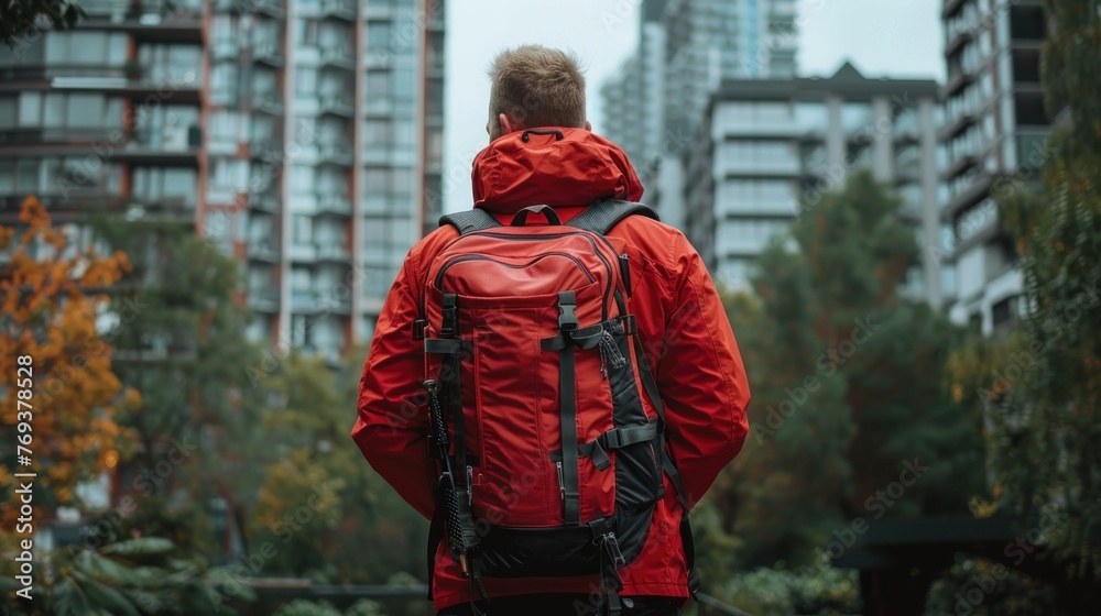 A man wearing a red jacket carrying a red backpack