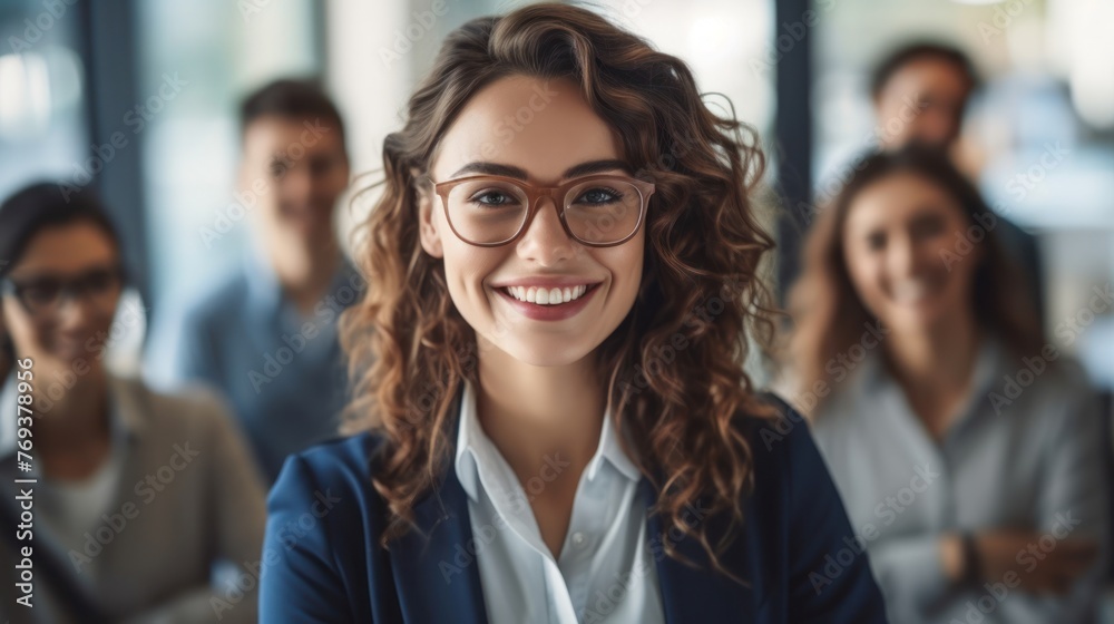 A woman wearing glasses stands in front of a group of people A woman wearing glasses stands in front of a group of people