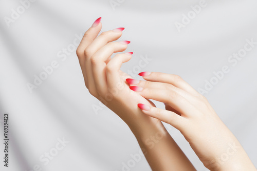 Girl's hands with a beautiful pale pink ombre manicure . Beautiful woman's hands on light background. Care about hand. Tender palm with natural manicure, clean skin. Light pink nails