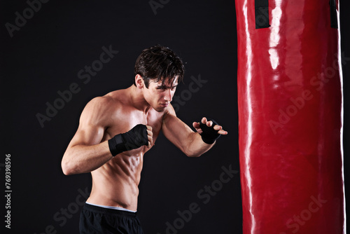 Man, punching bag or workout with fitness, exercise or fighter with progress or wellness with cardio. Boxer, practice or athlete with training, balance or martial arts with endurance and healthy guy © peopleimages.com