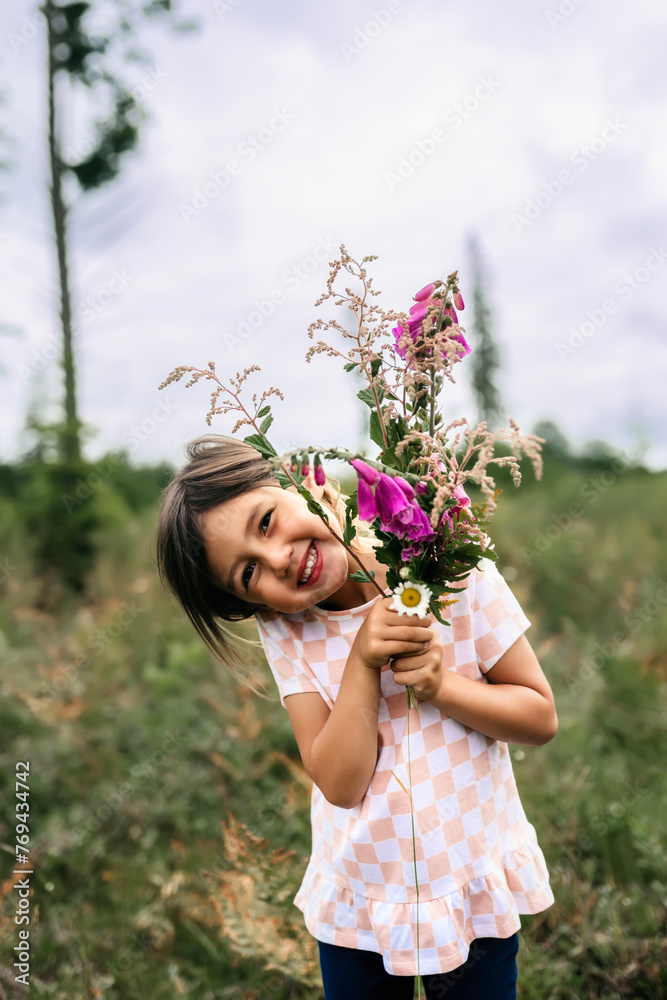 Asian girl smiling with flowers with the sun shining in field Asian girl smiling with flowers with the sun shining in field
