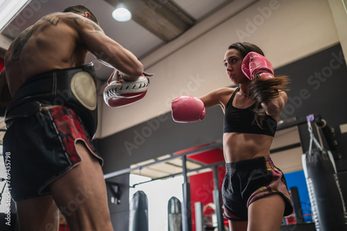 Female fighter sparring with personal coach during training session