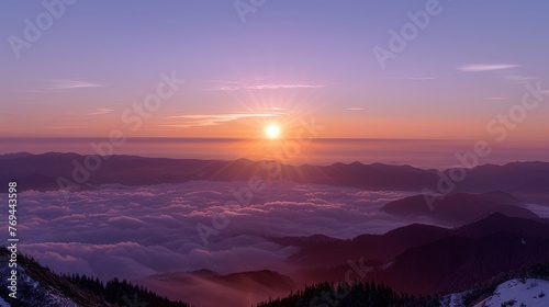 The sun is setting over the mountains, casting a warm glow over the landscape © hakule