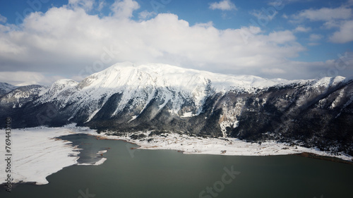 View of a frozen Lake with mountains covered with snow in the background. 