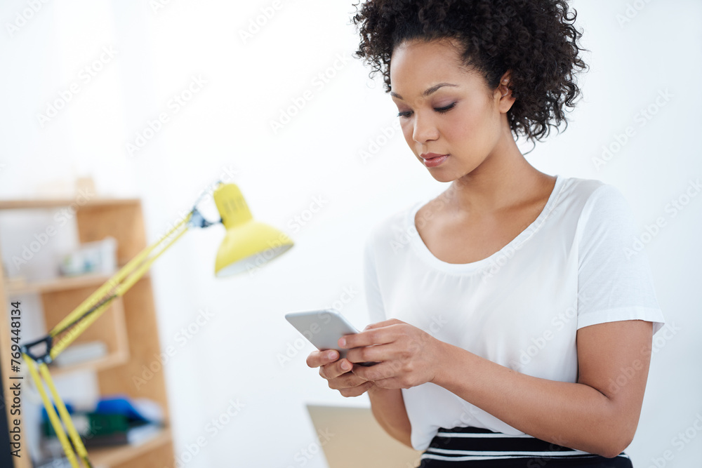 Business woman, typing and phone in office for social media, chat and communication in human resources. African worker, employee or young person reading email or information on mobile for contact Business woman, typing and phone in office for social media, chat and communication in human resources. African worker, employee or young person reading email or information on mobile for contact