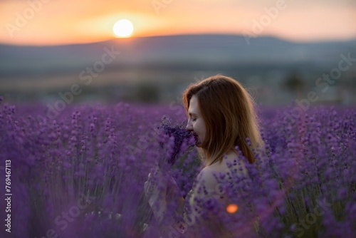 Woman poses in lavender field at sunset. Happy woman in yellow dress holds lavender bouquet. Aromatherapy concept, lavender oil, photo session in lavender