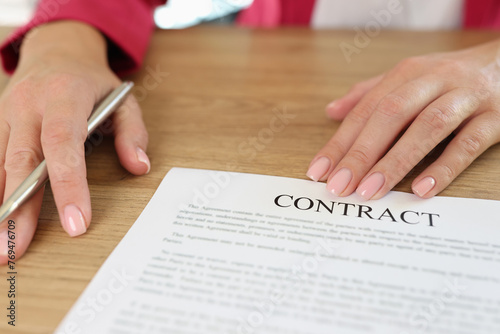 Female manager asks client to sign contract in her office.