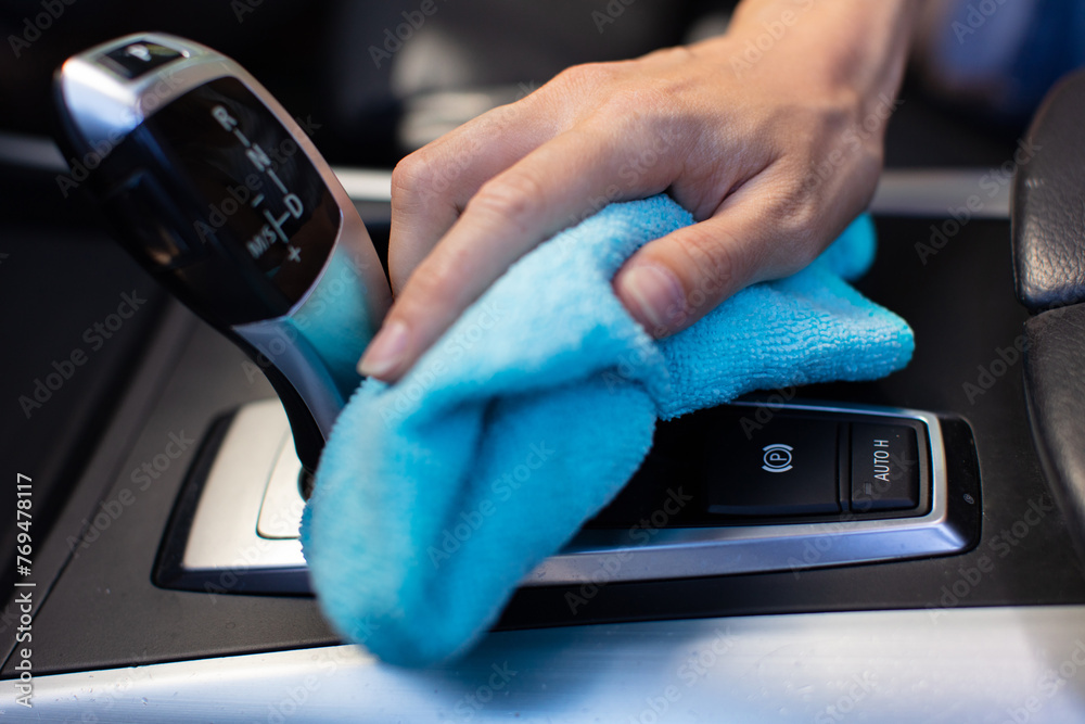 Fototapeta premium close up of male hand wiping out dust in car