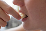 Detail of a Boy's Mouth Biting a Banana wedge