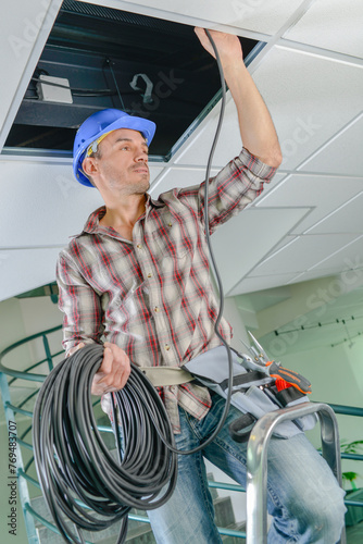 man is putting a wiring system photo