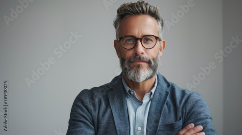 Portrait of a handsome mature man with gray hair and beard wearing glasses