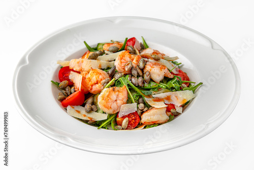 Easy diet salad with shrimp, pumpkin seeds and greens on a white plate. Banquet festive dishes. Gourmet restaurant menu. White background.