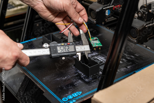 Engineer measures part created on 3D printer © Antonio