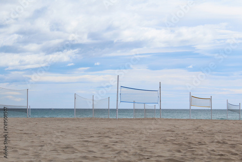 turbine on the beach, volleyball net on the beach, a beautiful view of the sandy beach with a blue sky on the sea © Iryna