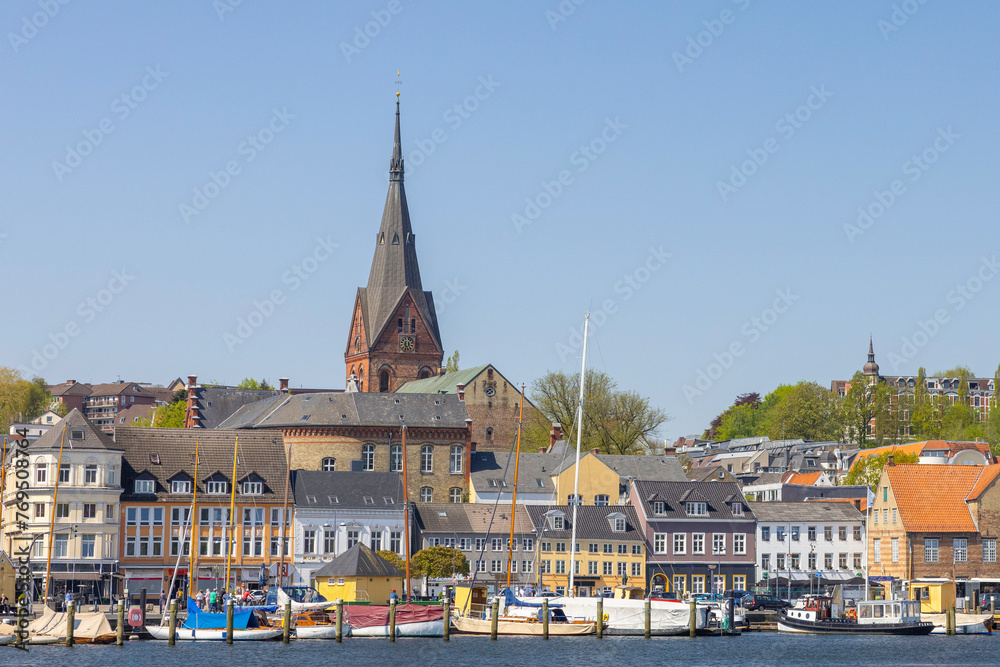 Obraz premium Happy walking along in Flensburg street (harbor) with old boats, Flensburg, Germany