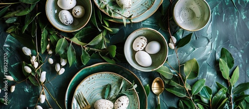 Easter dinner table decoration with ceramic plates and eggs nestled among greenery