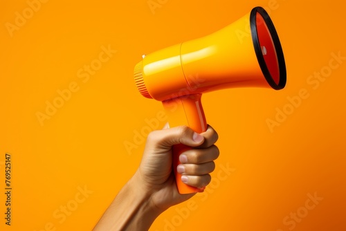 a hand holding a megaphone, set against an orange background, with a focus on marketing and sales