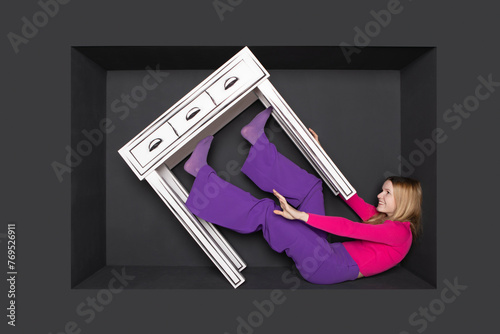 Teenage girl with table in alcove by black background photo
