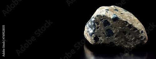 Kaersutite is a rare precious natural stone on a black background. AI generated. Header banner mockup with space.