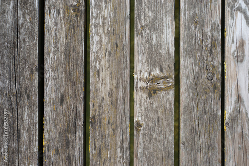 Closeup of peeling brown paint on wooden fence plank