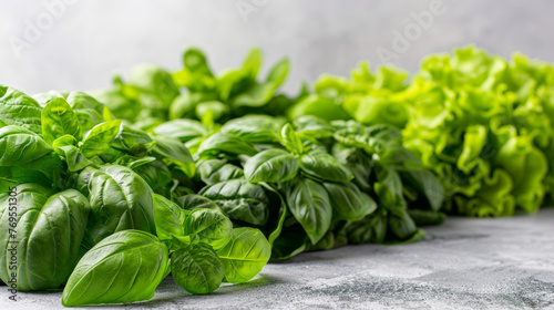 A bunch of green vegetables including basil  lettuce  and spinach are displayed on a table. The vegetables are fresh and vibrant  and they are arranged in a way that highlights their natural beauty