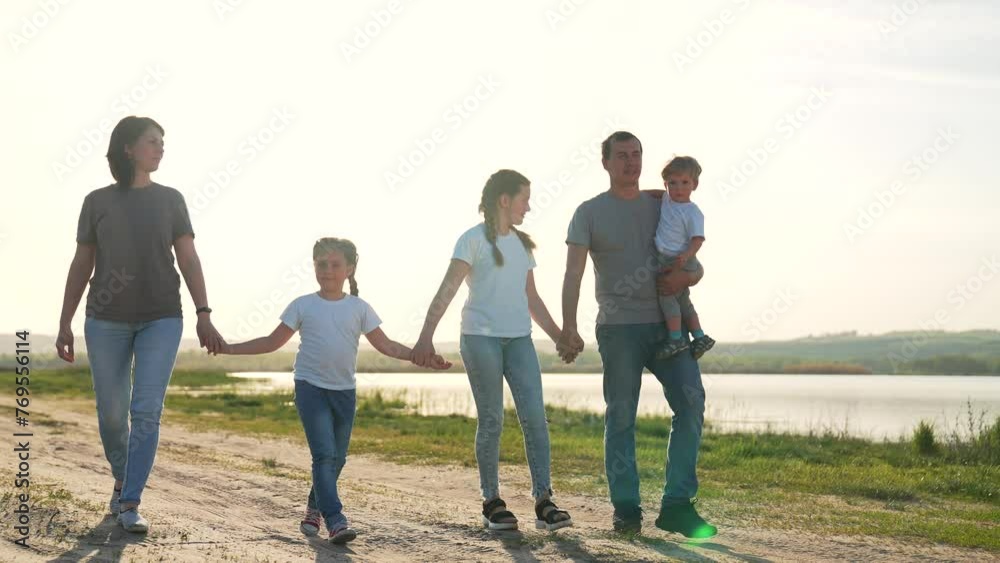 Happy family concept.parents with children walk in forest park at sunset.happy family holding hands.weekend together in nature.family vacation in field in fresh air.family communication in forest park Happy family concept.parents with children walk in forest park at sunset.happy family holding hands.weekend together in nature.family vacation in field in fresh air.family communication in forest park