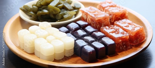 A wooden plate adorned with various candies and a bowl of fresh vegetables, showcasing a mix of comfort food and staple ingredients