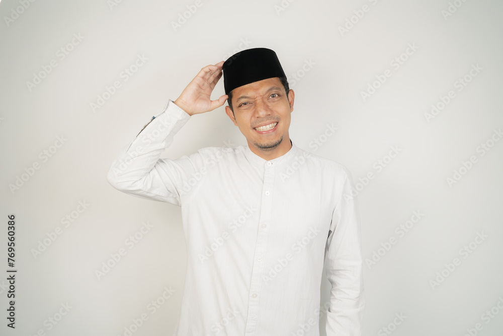 Asian Muslim man thinking about something touching his chin, wearing Arab costume at copy space on isolated background - obrazy, fototapety, plakaty 