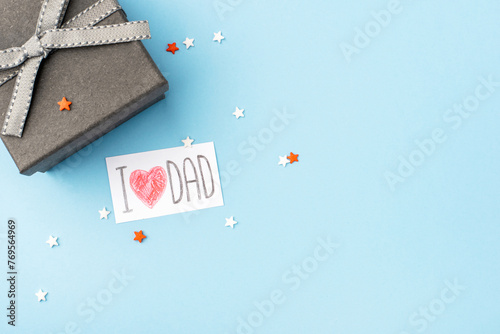 A gray gift box with a Father's Day greeting card on a blue background.