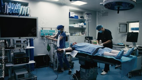 In the operating room, the surgical team prepares the patient for surgery. High tech medical technology, modern medicine, futuristic medical equipment, operation. photo