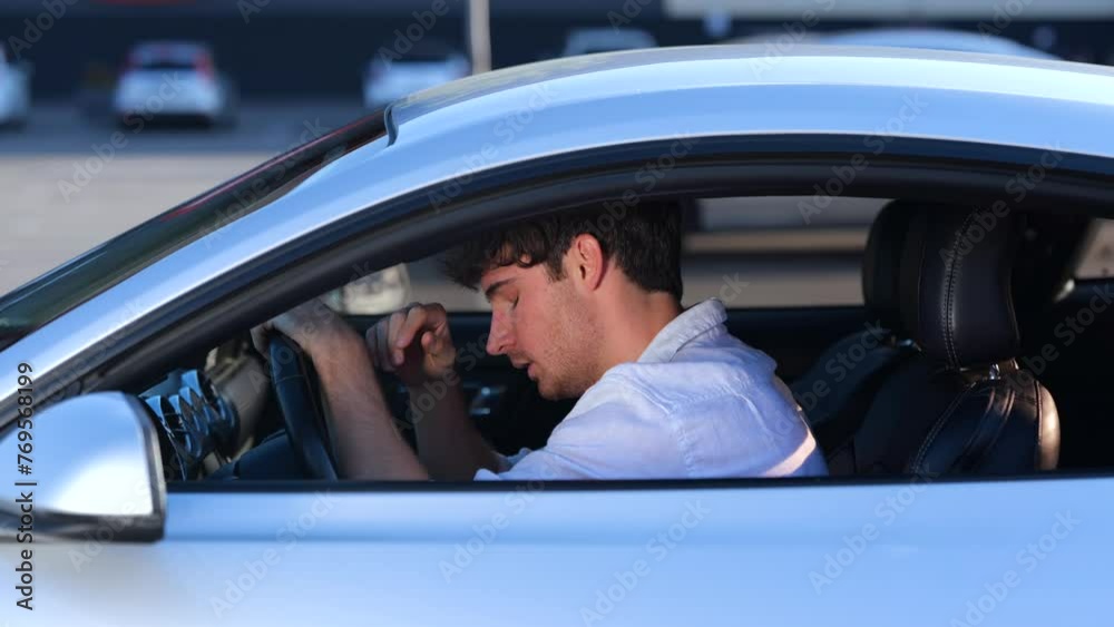 Young man taking off his glasses and putting his head on the steering wheel, tired from the trip. Transport and lifestyle concept. Slow motion Young man taking off his glasses and putting his head on the steering wheel, tired from the trip. Transport and lifestyle concept. Slow motion