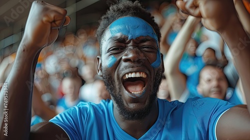 Excited man in blue, screaming in jubilation at a sports match.