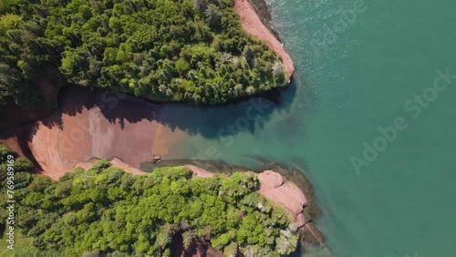 Bird's eye view drone shot on a beautiful sunny day revealing  the popular St Martins Cave located on the Bay of Fundy, in the Province of New Brunswick in Canada shot in 4k during a hot summer day. photo