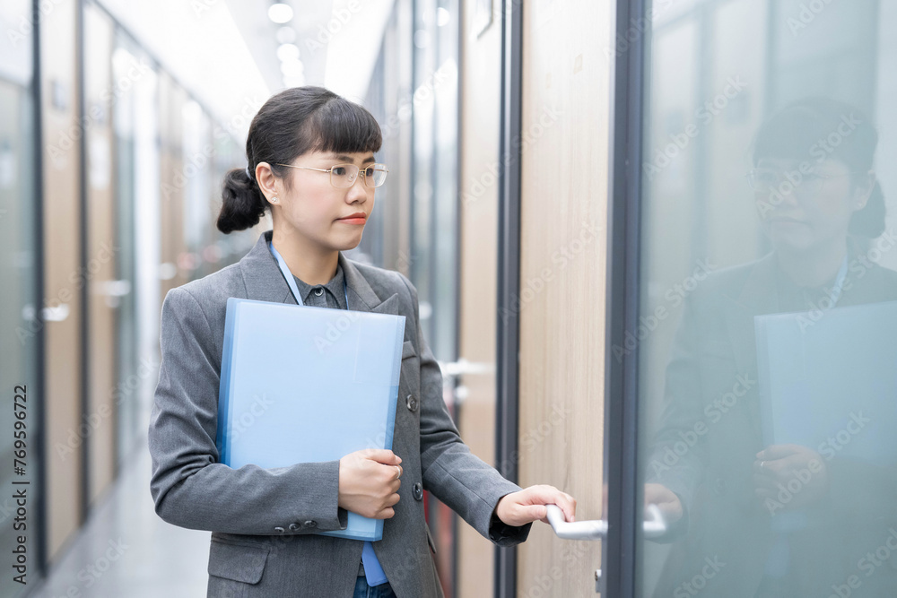 White-collar worker holding a folder and knocking on the door
