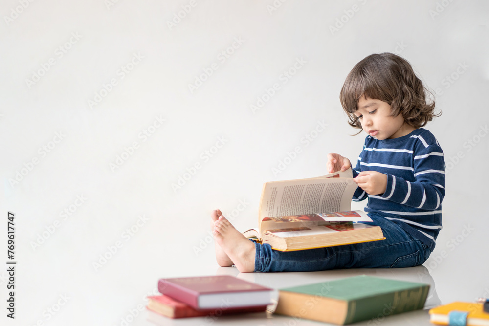 Education and back to school concept. Portrait of Happy little kindergarten child boy learning to read a book on the floor. Preschool children kids enjoy and fun study and doing homework at home. Education and back to school concept. Portrait of Happy little kindergarten child boy learning to read a book on the floor. Preschool children kids enjoy and fun study and doing homework at home.