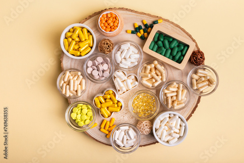 Different nutritional supplements, minerals and vitamins such as vitamin d3 softgels capsules, vitamin C, B, A, magnesium, lactase capsules, zinc, calcium, probiotics in jars to make better health. photo