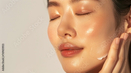 A close-up of a person's face with a focus on their closed eyes and the application of a creamy substance possibly a skincare product on their cheeks.