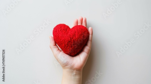 Human hand hold a red heart shape handmade craft on isolated white background. AI generated image photo