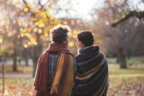 couple walking in the park wrapped in scarves