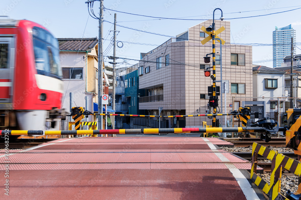 遮断機のある踏切を通過する赤い通勤電車 Stock Photo | Adobe Stock
