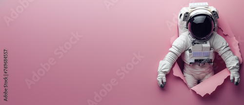 A solitary astronaut punctures through pink backdrop, hinting at isolation and the pursuit of dreams