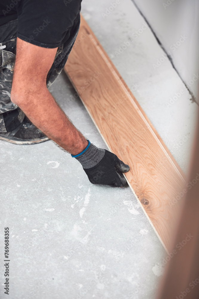 Professional handyman installing laminate flooring in a new apartment. Professional handyman installing laminate flooring in a new apartment.