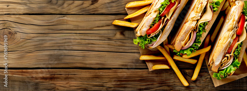 Sandwich with french fries on wooden background