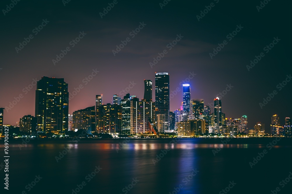 Stunning landscape of the illuminated modern city at the waterfront at night