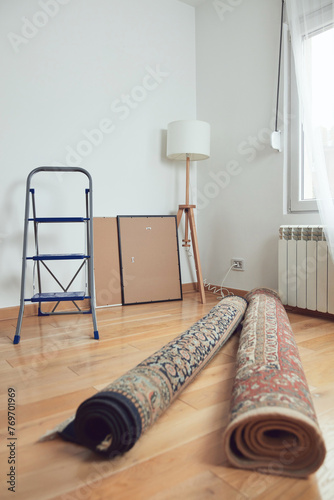 Rolled rugs, painting and ste ladder in the apartment.