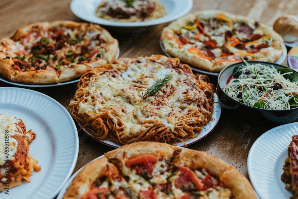 Vivid view of a variety of delicious pizzas arranged on a table Vivid view of a variety of delicious pizzas arranged on a table
