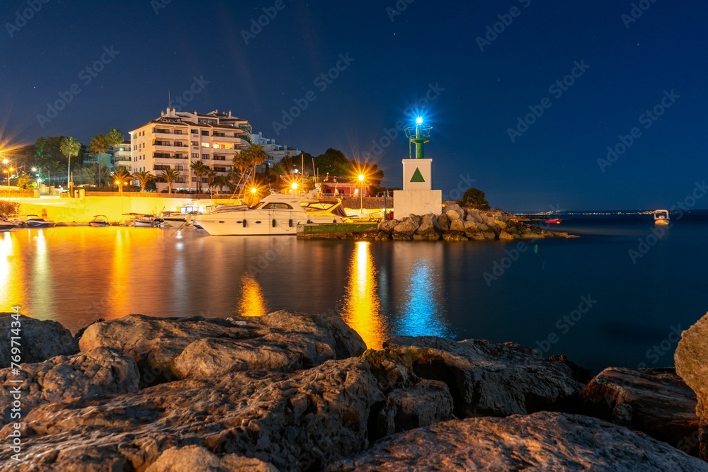 Stunning landscape with a picturesque rocky shoreline illuminated by the lights in Mallorca, Spain