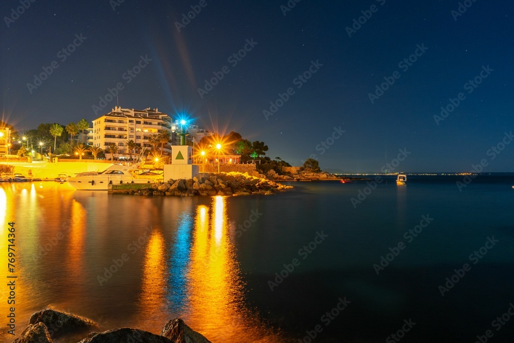 Scenic shot of a city skyline reflected in the tranquil waters of the sea in Mallorca, Spain