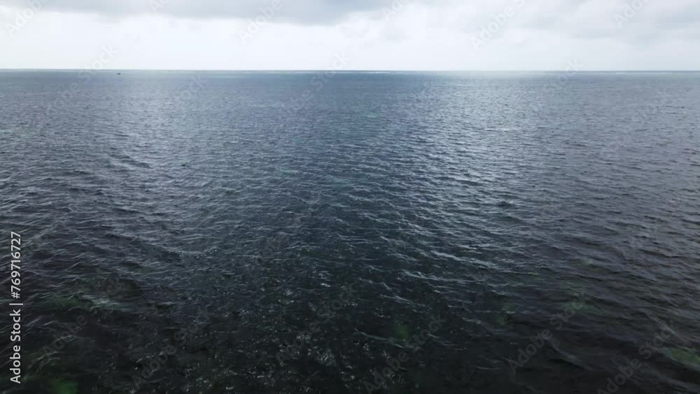 Aerial video of calm waves of the crystal clear sea on a sunny day
