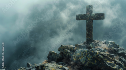 A detailed photograph capturing the weathered texture of a stone cross at the mountains peak surrounded by misty clouds